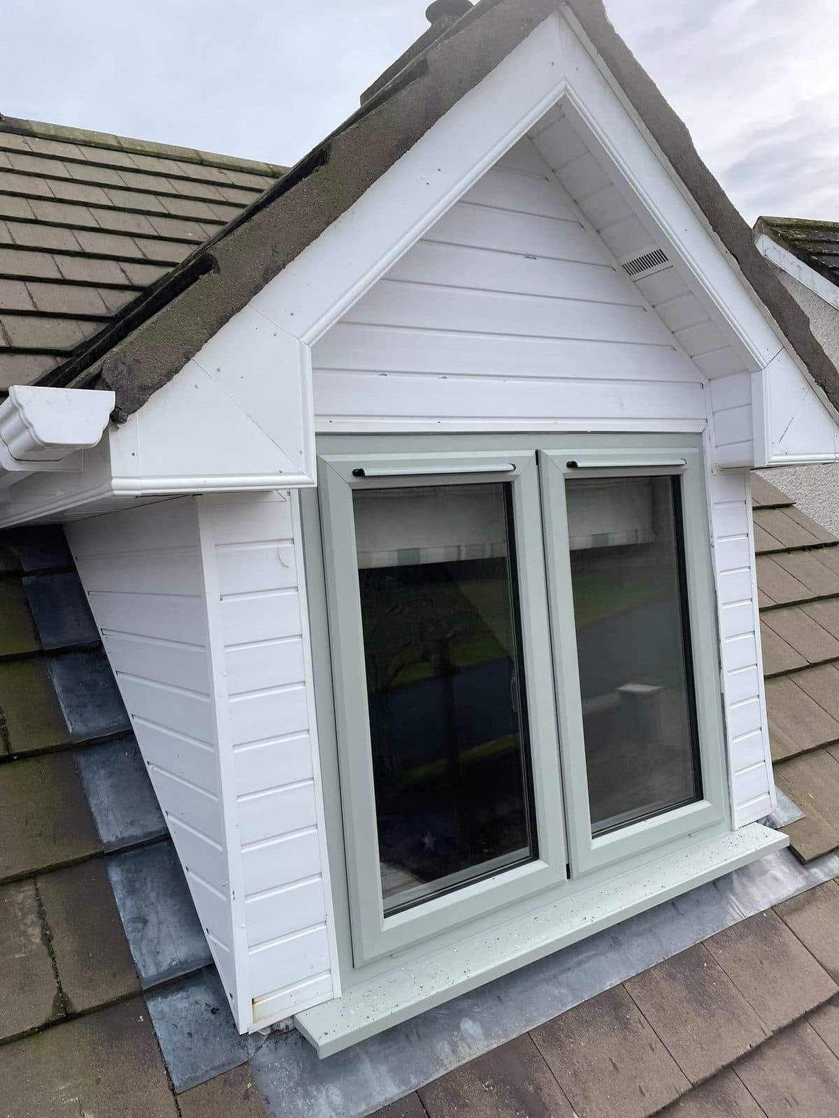 Dormer with a white finish around a new window